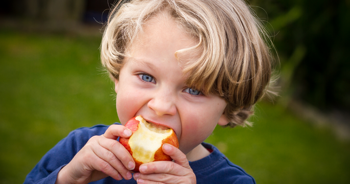 enfant croquant une pomme